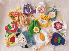 many crocheted items are laid out on a white surface with flowers and leaves