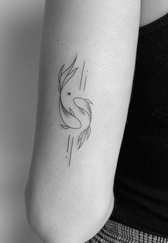 a black and white photo of a woman's arm with a fish tattoo on it