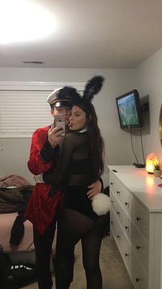 a man and woman dressed up in costumes taking a selfie with their cell phones