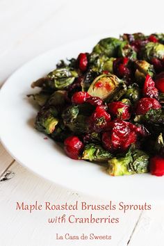 a white plate topped with brussel sprouts and cranberries