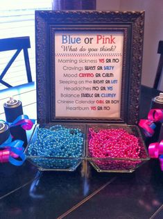 there is a sign that says blue or pink next to two containers with beads in them