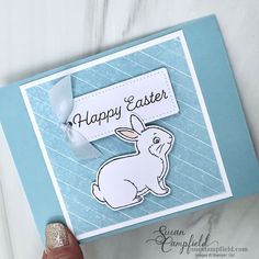 a hand holding up a card with an image of a rabbit on it and the words happy easter