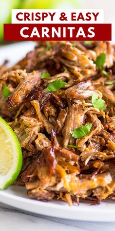 shredded pork with limes and cilantro on a white plate next to lime wedges