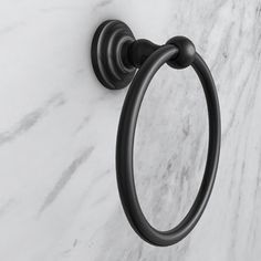 a black towel ring on a marble wall