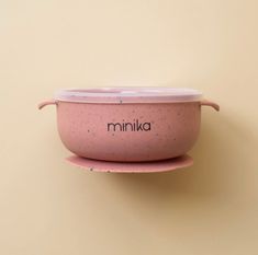 a pink bowl sitting on top of a plate with the word mimika written in it