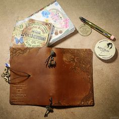 the contents of a leather journal are laid out on the floor