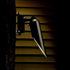 a black lamp hanging from the side of a wall