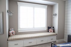 a window seat in a bedroom with white shutters on the windowsill and two star wars themed pillows