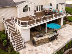 an aerial view of a house with patio furniture and stairs leading up to the upper level