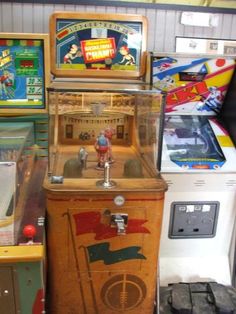 an old fashioned pinball machine sitting on top of a wooden table next to other games