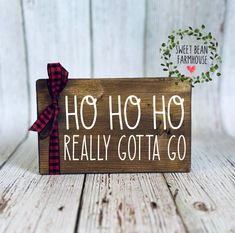 a wooden sign with the words ho ho really gota go on it and a red bow