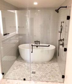 a white bath tub sitting inside of a bathroom next to a walk in shower stall