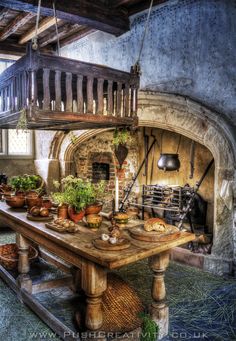 an old fashioned kitchen with potted plants and pots on the table in front of it