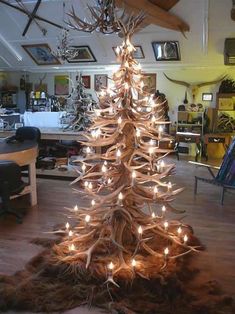 a christmas tree made out of antlers is lit up in the middle of a room