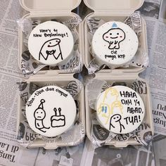 four decorated cupcakes in an open box