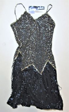 Vintage Vanna white Beaded Black / gold gown small Clingy Unused ...with tage chest 32 hips 34 / 36 moving black fringe on shirt Fitted Sequin Flapper Dress For Prom, Glamorous Fringe Dress For Costume Party, Fitted Beaded Fringe Dresses For Prom, Fitted Flapper Dress With Rhinestone Fringe For Prom, Fitted Flapper Evening Dress For Party, Glamorous Fitted Flapper Evening Dress, Sleeveless Beaded Fringe Flapper Dress For Evening, Fitted Flapper Style Cocktail Evening Dress, Night Out Beaded Fringe Flapper Dress