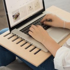 a person using a laptop computer on a wooden table