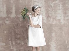 a woman in a white dress holding a bouquet of flowers