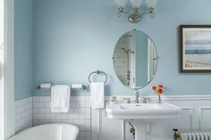 a bathroom with blue walls and white fixtures