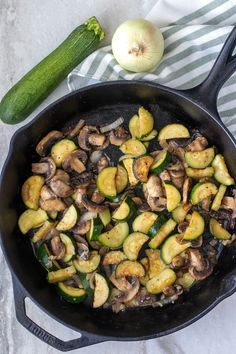 an iron skillet filled with mushrooms and zucchini