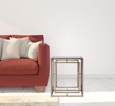 a living room with a red couch and two side tables in front of the couch