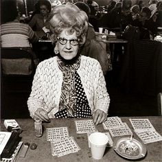 an older woman sitting at a table with cards and cups