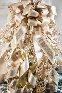 a christmas tree decorated with gold and silver ribbons