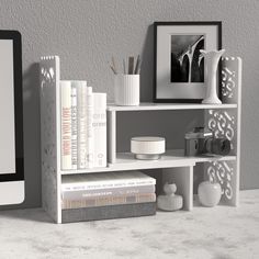 a computer monitor sitting on top of a desk next to a bookshelf filled with books