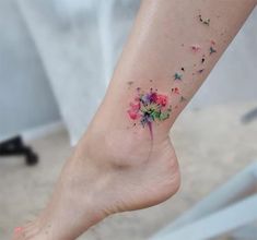 a woman's foot with a colorful flower tattoo on her left ankle and the word love written in it