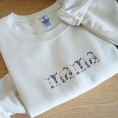 Each sweatshirt is embroidered with dark blue and neutral thread. Mama is spelled out with different flowers within the letters. Sweaters run slightly big, but if you're looking for a true oversized look size up. Inside the sweatshirt is lined with fleece. 50% cotton, 50% polyester Oversized Fall Sweatshirt With Letter Embroidery, Oversized Sweatshirt With Letter Embroidery For Fall, Fall Sweatshirt For Loungewear With Embroidered Text, Fall Loungewear Sweatshirt With Embroidered Text, Cream Cotton Sweatshirt With Embroidered Text, Fleece Sweatshirt With Letter Embroidery For Fall, Cream Tops With Letter Embroidery For Fall, Fall Fleece Sweatshirt With Embroidered Text, Cream Cotton Sweatshirt With Letter Embroidery