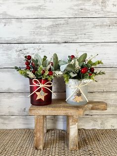 two tin canisters with flowers and greenery tied to them on a bench