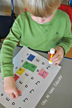 a little boy that is sitting at a table with some type of writing on it