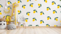 a room with yellow lemons and green leaves on the wall next to a white chair