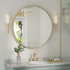 a bathroom vanity with a round mirror above it