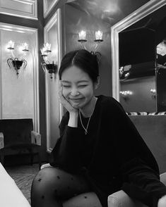 black and white photograph of a woman sitting on a couch with her hand under her chin