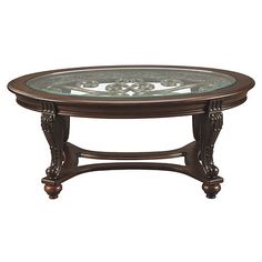 a glass top coffee table with ornate carvings on the bottom and sides, in an antique style