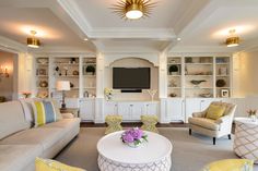 a living room filled with furniture and a flat screen tv mounted to the side of a wall