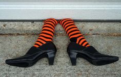 a pair of black and orange striped socks with high heeled shoes on the ground