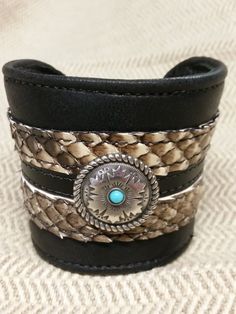 This is a 2 1/2 " wide cuff bracelet made with soft black cowhide with genuine python trim, and a beautiful concho accent. Buckle closure in back makes it adjustable.It is a very well made piece of wearable art for any occasion. Adjustable Black Hand Tooled Bracelet, Bohemian Black Cuff Bracelet, Southwestern Adjustable Leather Cuff Bracelet, Adjustable Southwestern Leather Cuff Bracelet, Handmade Western Cuff Bracelet, Black Concho Jewelry For Rodeo, Western Black Leather Jewelry, Black Leather Western Jewelry, Western Style Black Leather Jewelry