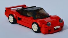 a red lego sports car on a white surface