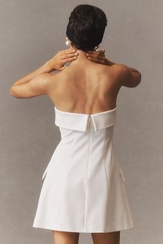 the back of a woman's dress with her hand on her shoulder and hands behind her head