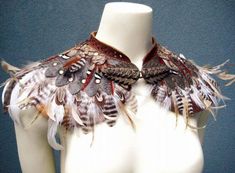 a white mannequin with brown feathers on it's chest and collar,