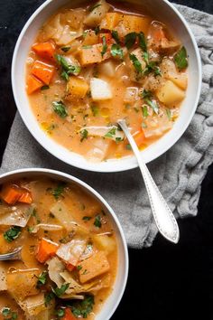 two bowls filled with soup on top of a table next to a napkin and spoon