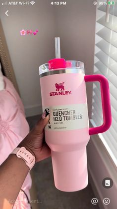 a person holding a pink tumbler cup in their hand