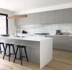 a kitchen with two bar stools next to an island