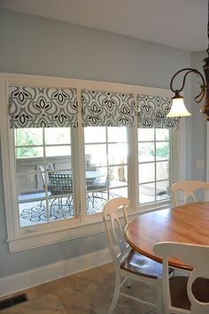 a dining room table with chairs and a chandelier hanging from the ceiling