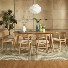 a wooden table with chairs and vases on top of it in front of a wall