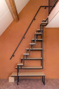 a set of stairs leading up to the second floor in a home with an orange wall