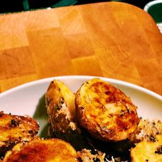 a white plate topped with cooked potatoes on top of a wooden table