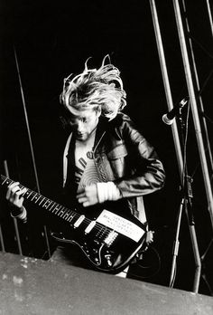 black and white photograph of man playing guitar on stage